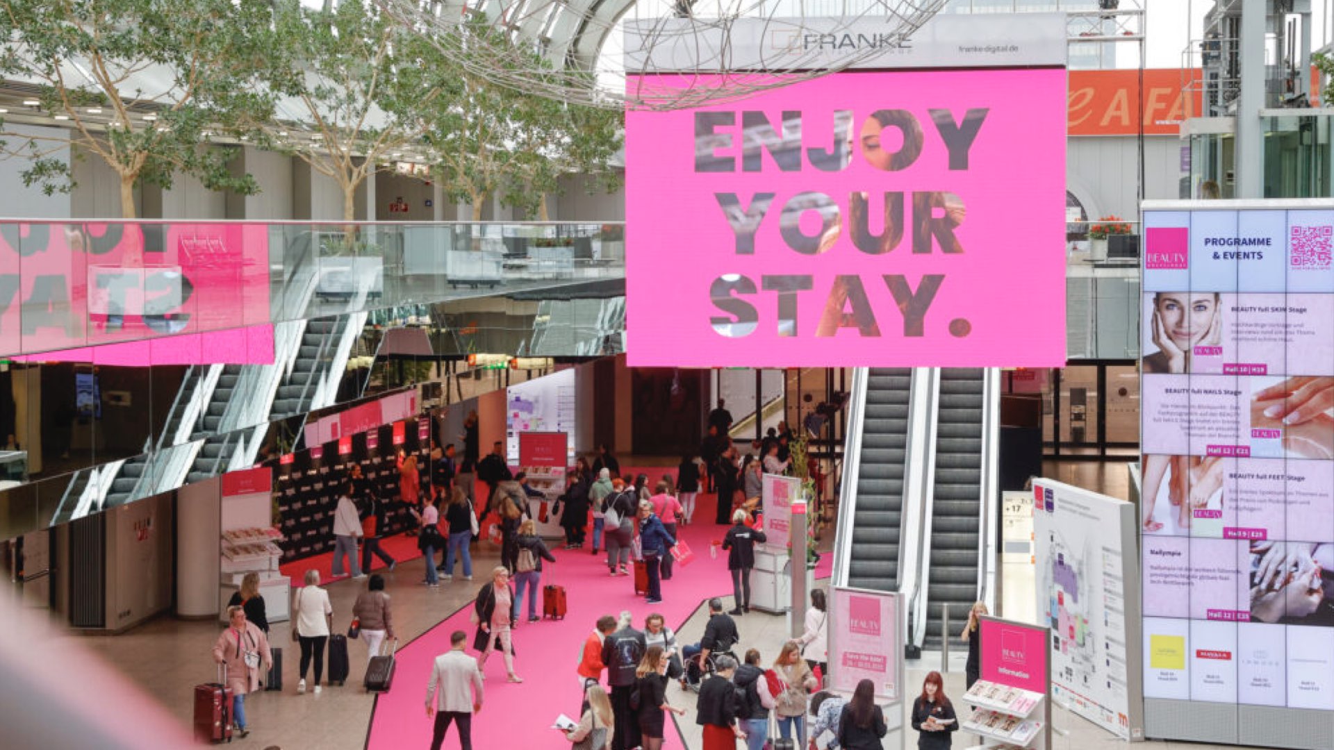 Beauty Düsseldorf: ENJOY YOUR STAY hanging signage in the hall