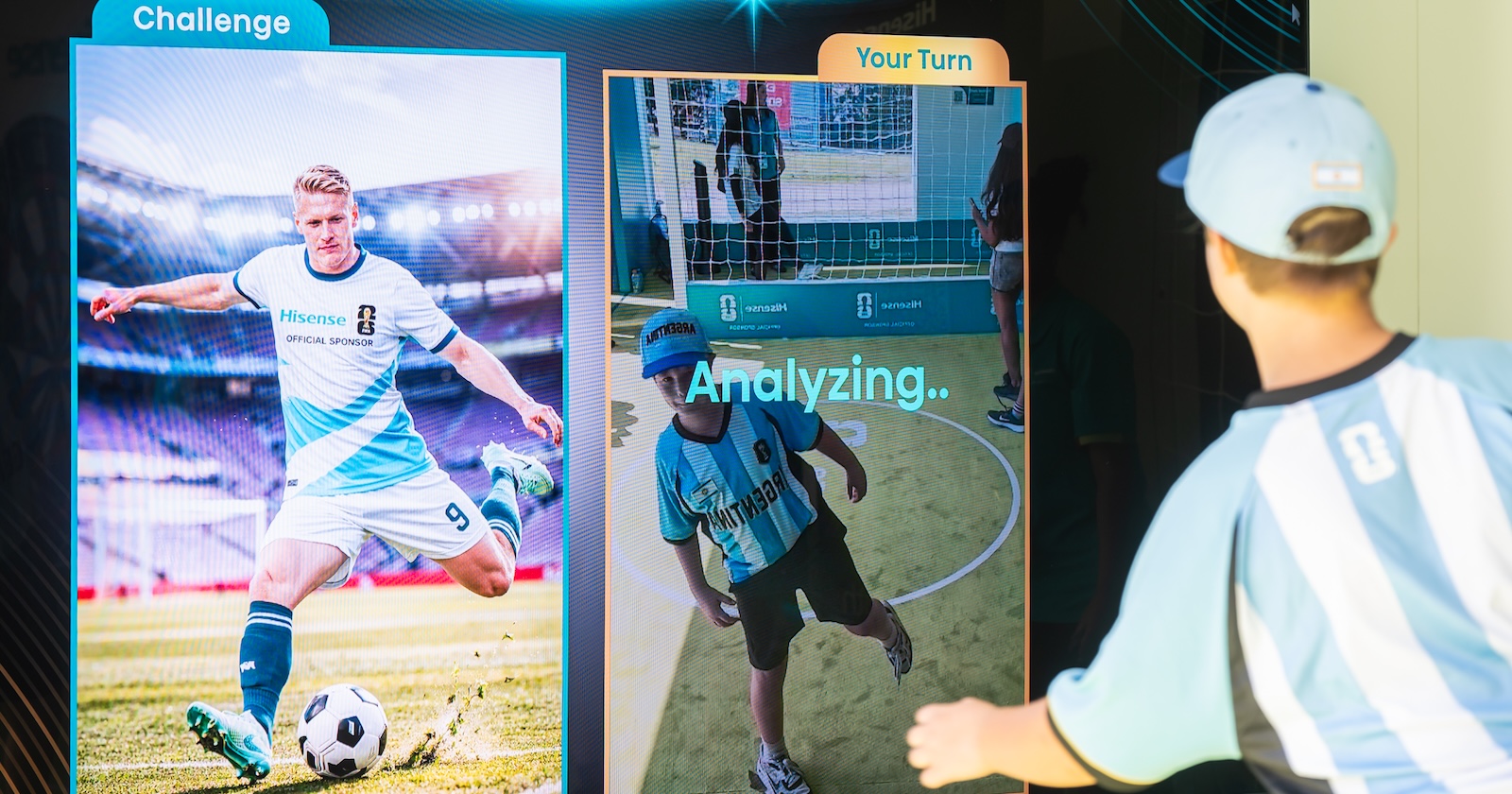 A boy in an Argentina jersey kicks toward a screen during the Hisense Champion Frame activation, which analyzes his motion beside a professional athlete's Hisense-branded reference image.