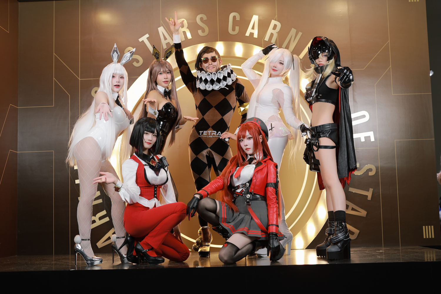 Group photo of cosplayers in NIKKE character costumes on the "Stars Carnival" stage