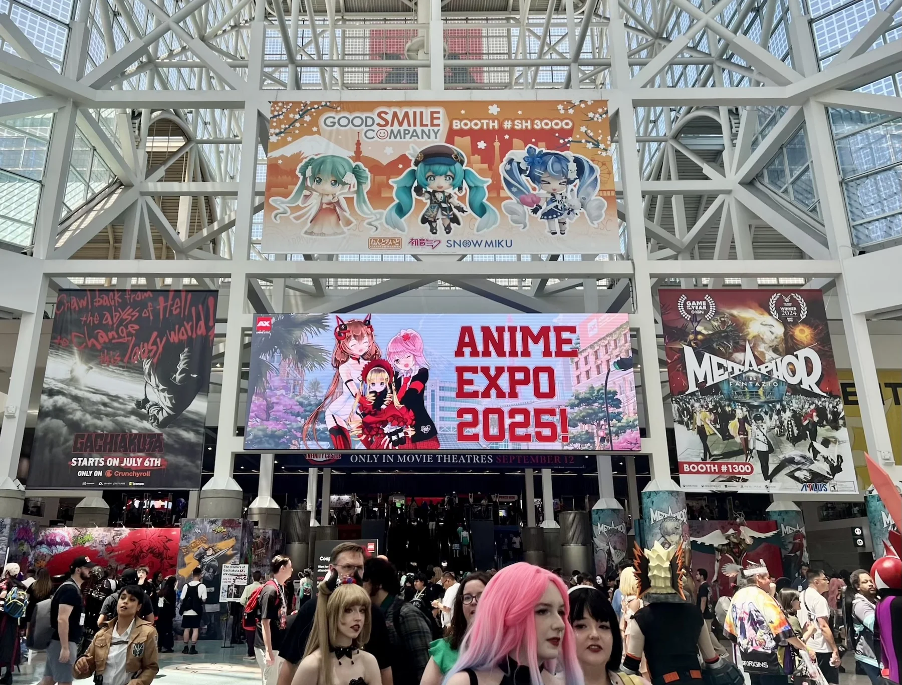 Anime Expo 2025 exhibition floor at Los Angeles Convention Center with cosplay attendees and game booths
